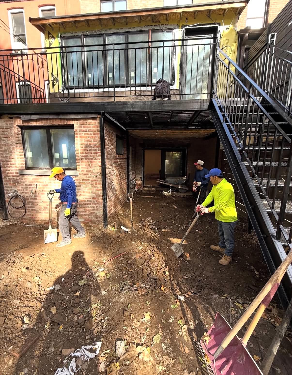 Cinder block retaining wall under construction on a sloped New York City backyard